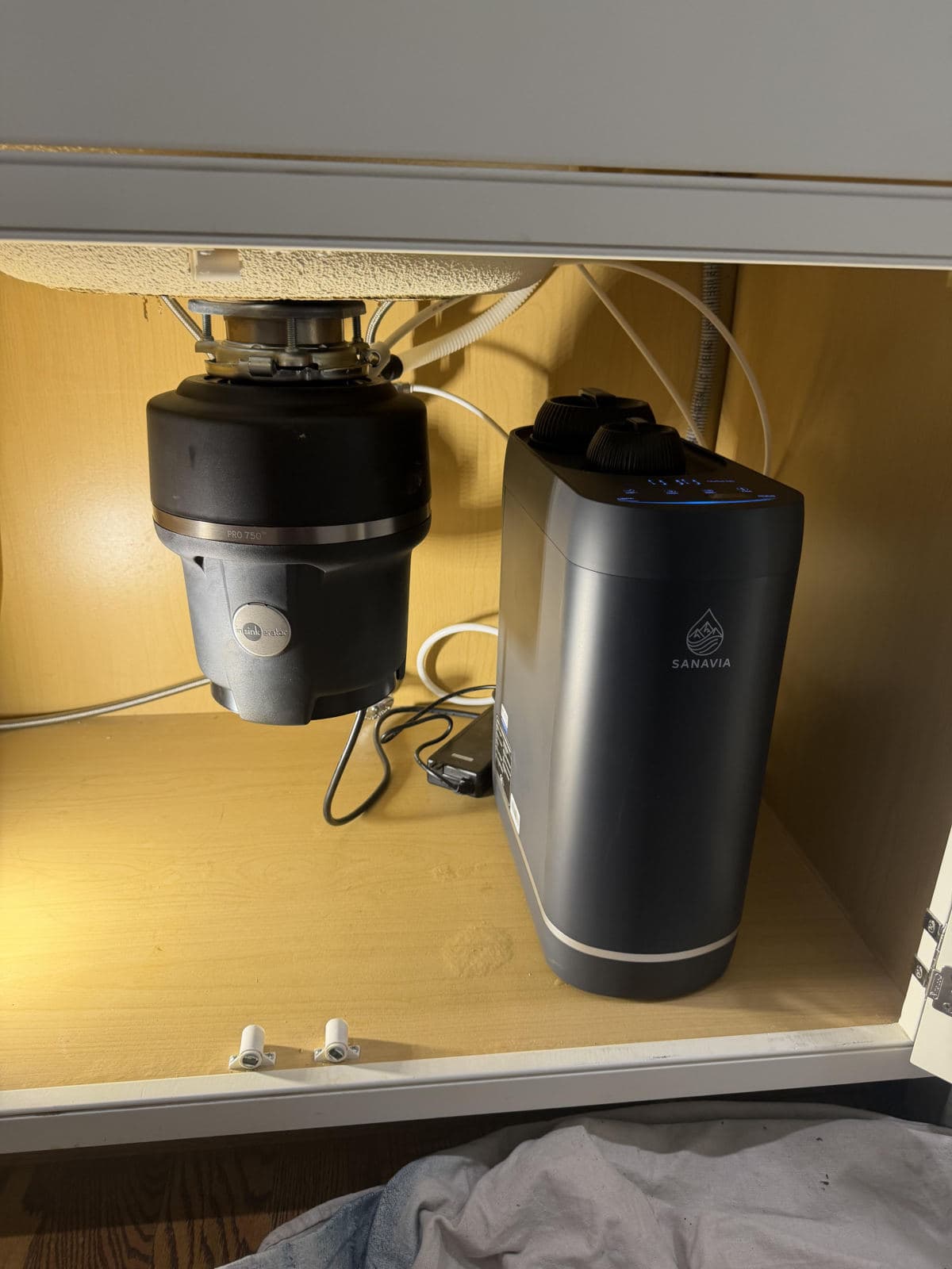 The Hydra installed next to the garbage disposal under a lit kitchen sink