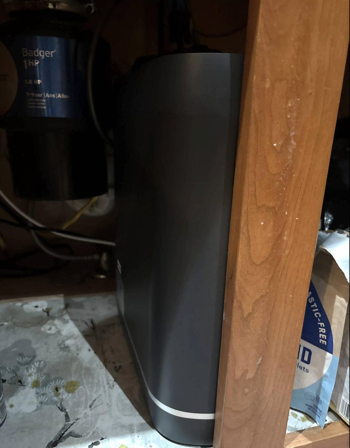 The Hydra installed beside a Badger garbage disposal under a wood kitchen cabinet
