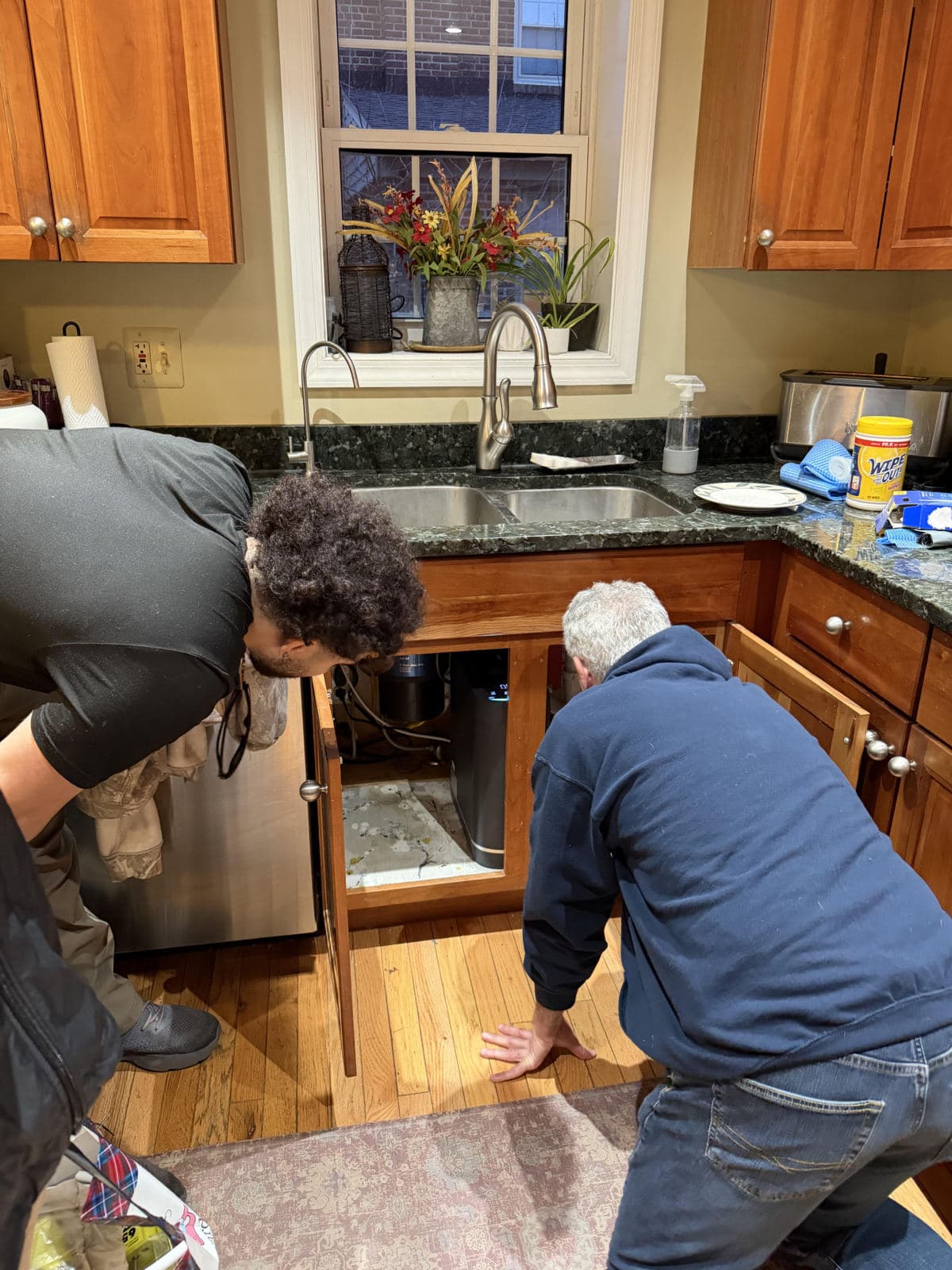 The Sanavia team fitting the Hydra under Patrick's kitchen sink